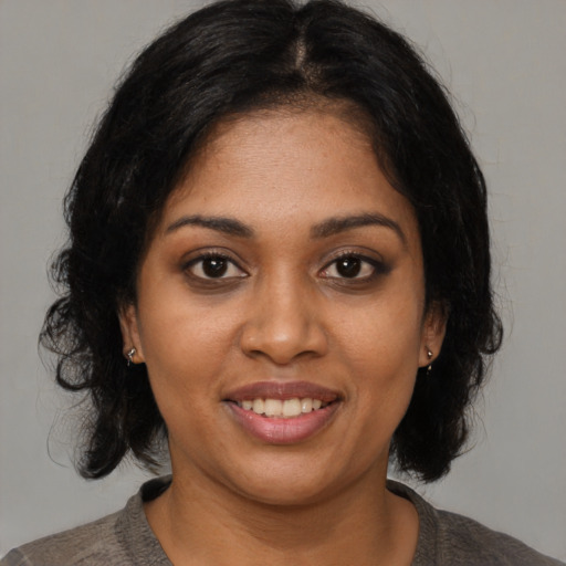 Joyful black young-adult female with medium  brown hair and brown eyes