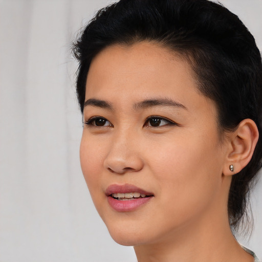 Joyful asian young-adult female with medium  black hair and brown eyes