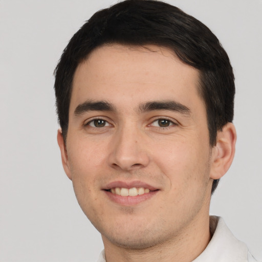 Joyful white young-adult male with short  black hair and brown eyes