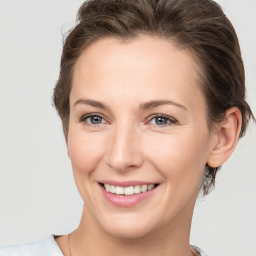 Joyful white young-adult female with short  brown hair and grey eyes