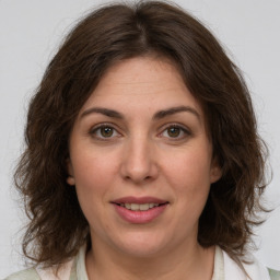 Joyful white young-adult female with medium  brown hair and green eyes