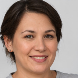 Joyful white adult female with medium  brown hair and brown eyes