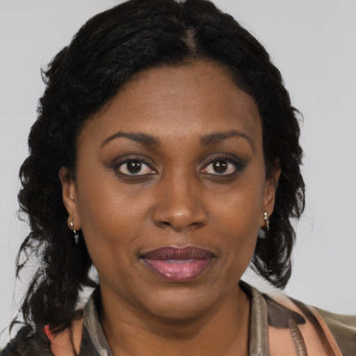 Joyful black adult female with long  brown hair and brown eyes