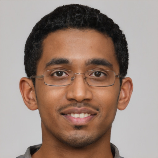Joyful black young-adult male with short  black hair and brown eyes