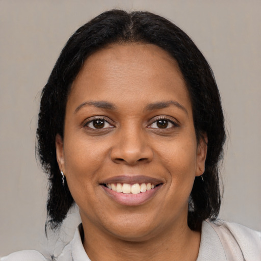 Joyful black young-adult female with medium  black hair and brown eyes