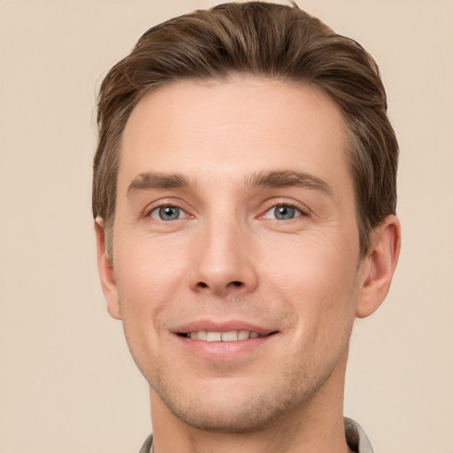 Joyful white young-adult male with short  brown hair and grey eyes