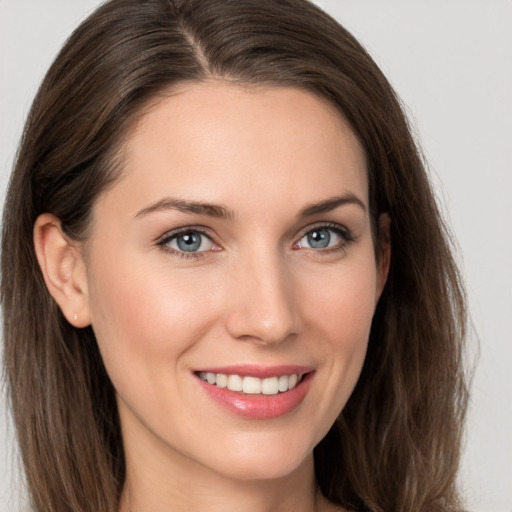 Joyful white young-adult female with long  brown hair and grey eyes