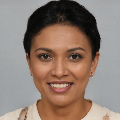 Joyful latino young-adult female with short  black hair and brown eyes