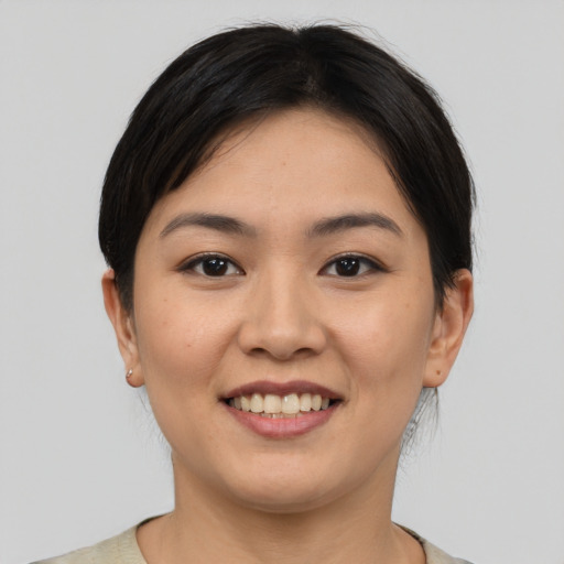 Joyful asian young-adult female with short  brown hair and brown eyes
