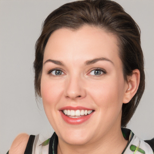 Joyful white young-adult female with medium  brown hair and green eyes