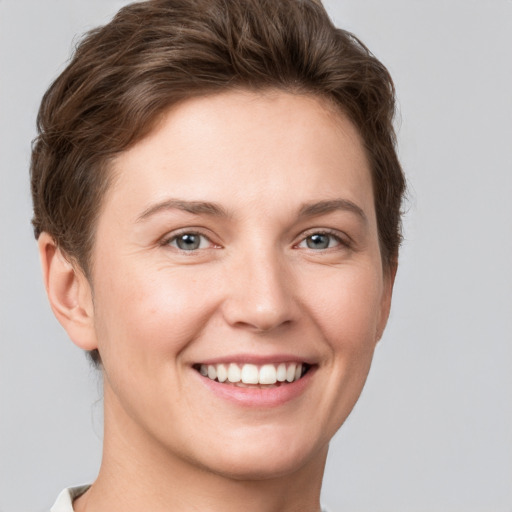 Joyful white young-adult female with short  brown hair and grey eyes