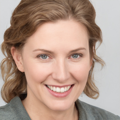 Joyful white young-adult female with medium  brown hair and blue eyes