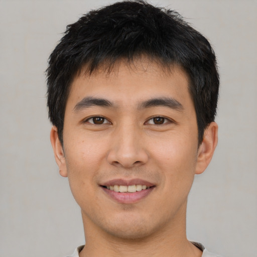 Joyful asian young-adult male with short  brown hair and brown eyes