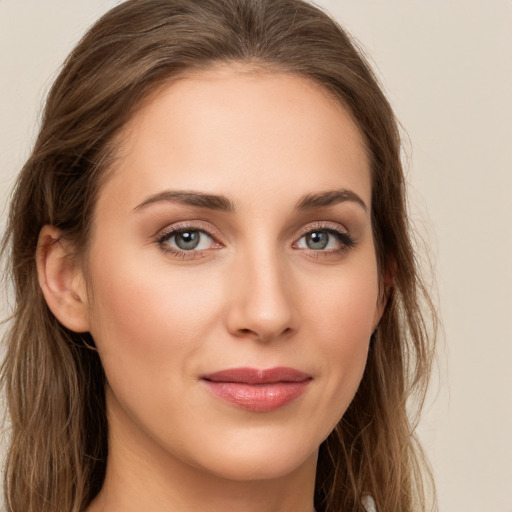 Joyful white young-adult female with long  brown hair and green eyes