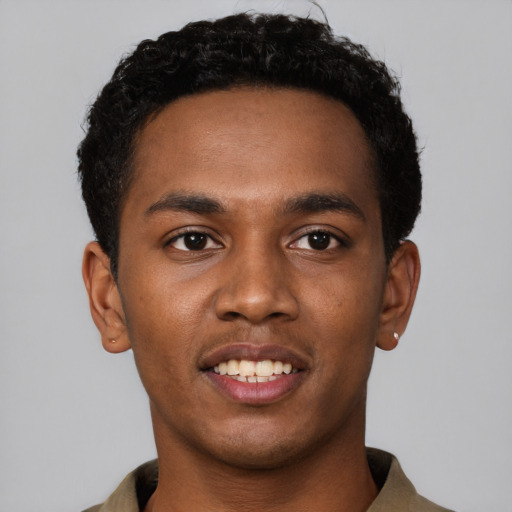 Joyful black young-adult male with short  brown hair and brown eyes