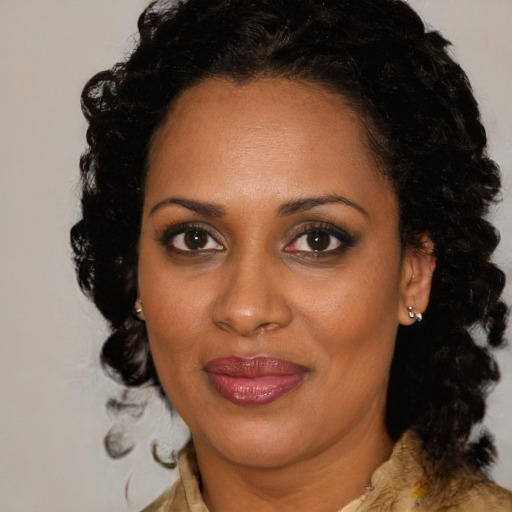 Joyful black adult female with medium  brown hair and brown eyes