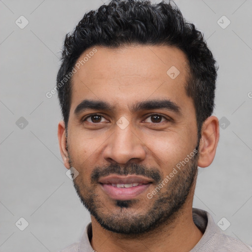 Joyful latino young-adult male with short  black hair and brown eyes