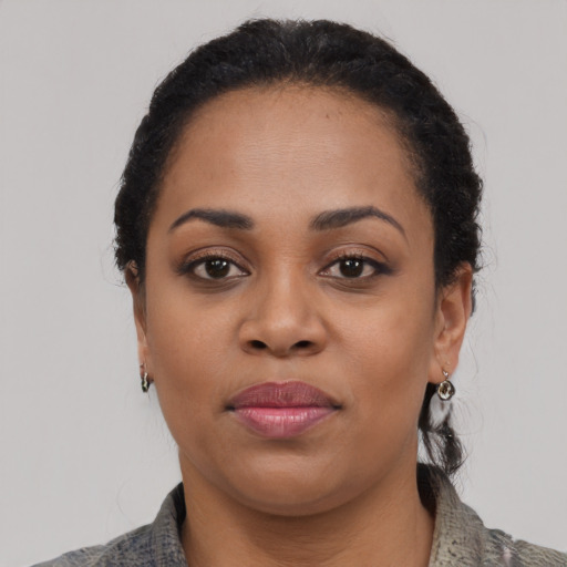 Joyful black young-adult female with medium  black hair and brown eyes