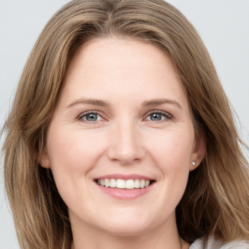 Joyful white young-adult female with long  brown hair and grey eyes