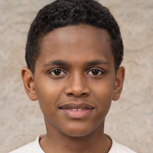 Joyful black child male with short  brown hair and brown eyes