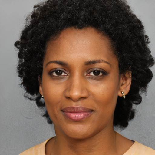 Joyful black young-adult female with medium  black hair and brown eyes