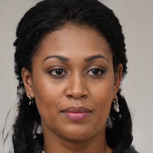 Joyful black young-adult female with long  brown hair and brown eyes
