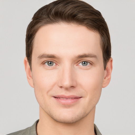 Joyful white young-adult male with short  brown hair and grey eyes