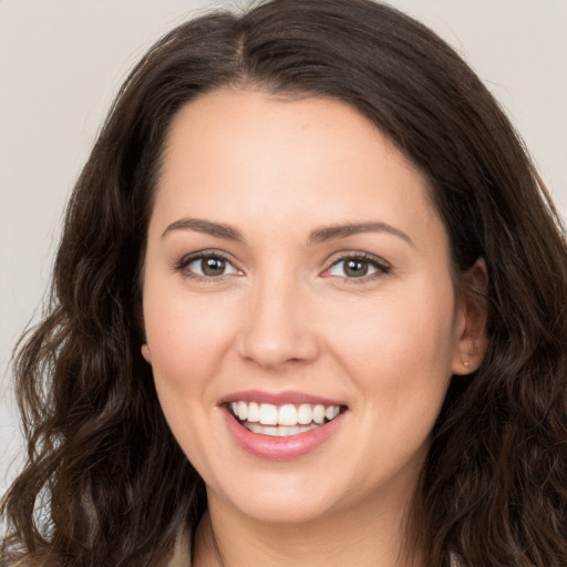 Joyful white young-adult female with long  brown hair and brown eyes