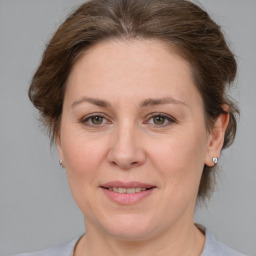 Joyful white adult female with medium  brown hair and grey eyes