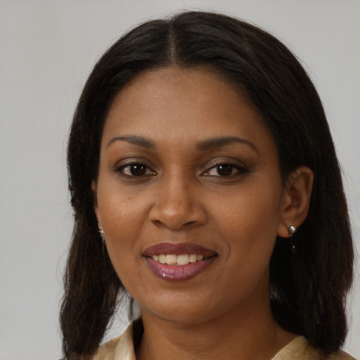 Joyful black adult female with long  brown hair and brown eyes