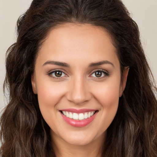 Joyful white young-adult female with long  brown hair and brown eyes