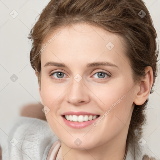 Joyful white young-adult female with medium  brown hair and blue eyes