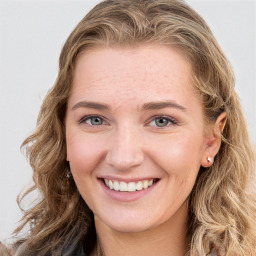 Joyful white young-adult female with long  brown hair and green eyes