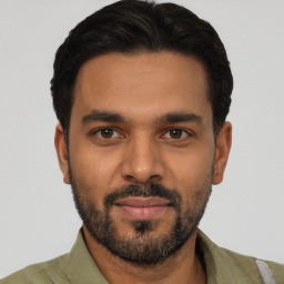 Joyful latino young-adult male with short  black hair and brown eyes