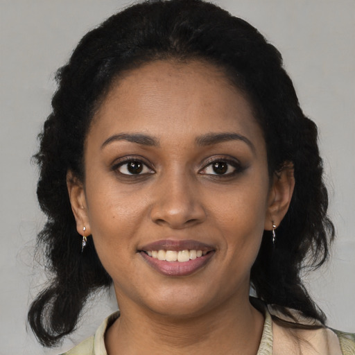Joyful black young-adult female with long  black hair and brown eyes