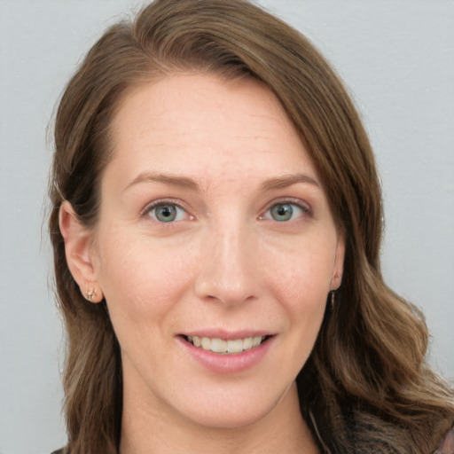 Joyful white young-adult female with long  brown hair and blue eyes