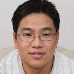 Joyful asian young-adult male with short  brown hair and brown eyes