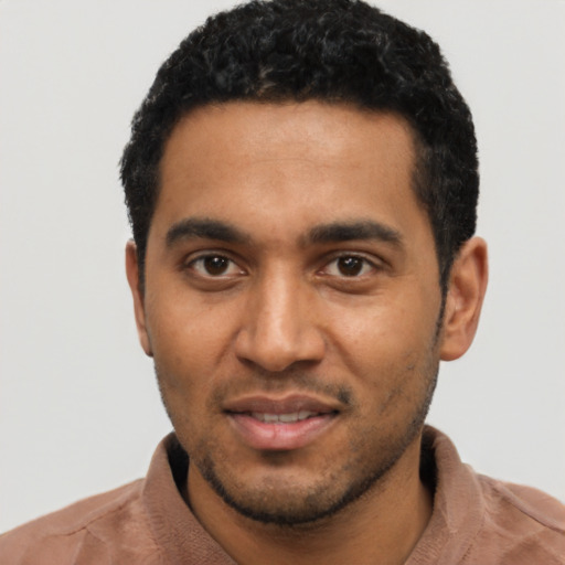 Joyful black young-adult male with short  black hair and brown eyes