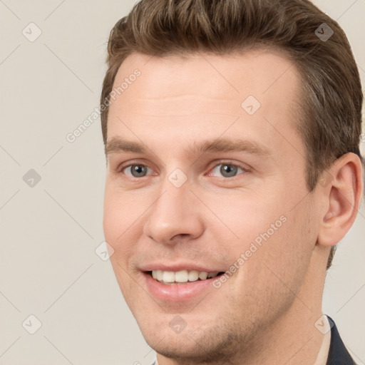 Joyful white young-adult male with short  brown hair and grey eyes