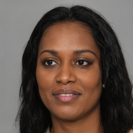 Joyful black young-adult female with long  black hair and brown eyes