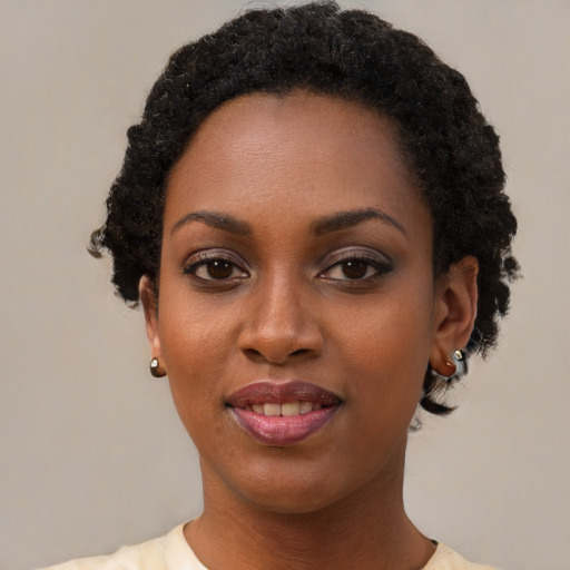Joyful black young-adult female with short  black hair and brown eyes
