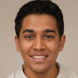 Joyful latino young-adult male with short  black hair and brown eyes