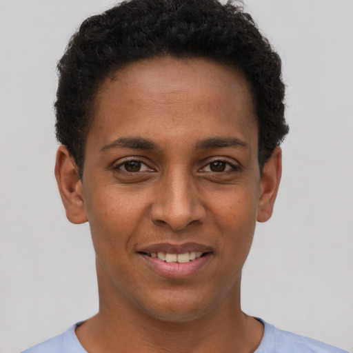 Joyful black young-adult female with short  brown hair and brown eyes
