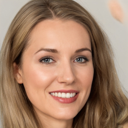 Joyful white young-adult female with long  brown hair and brown eyes