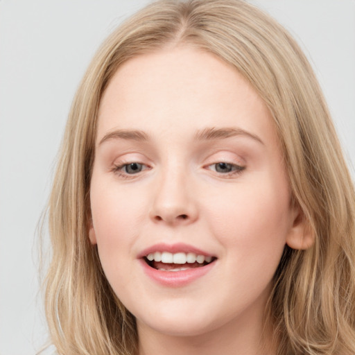 Joyful white young-adult female with long  brown hair and blue eyes