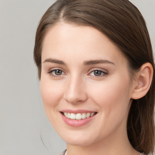 Joyful white young-adult female with long  brown hair and grey eyes