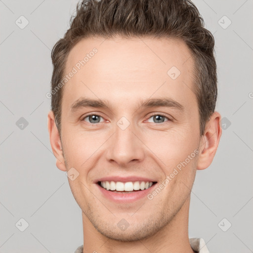 Joyful white young-adult male with short  brown hair and grey eyes