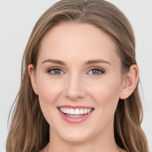 Joyful white young-adult female with long  brown hair and blue eyes