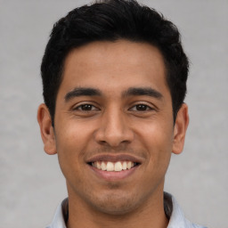 Joyful latino young-adult male with short  black hair and brown eyes