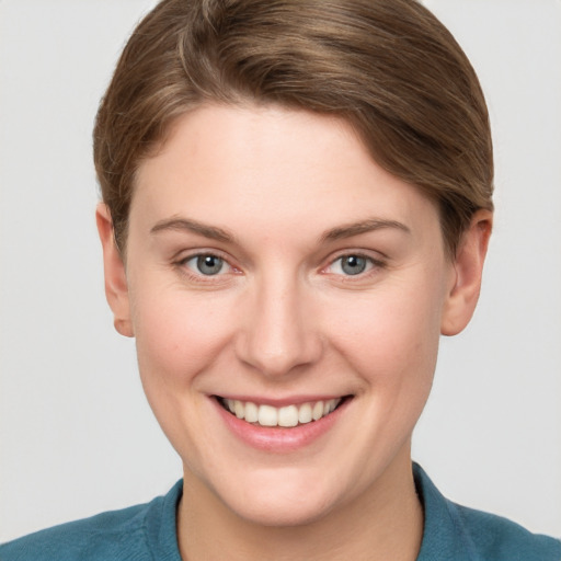 Joyful white young-adult female with short  brown hair and blue eyes